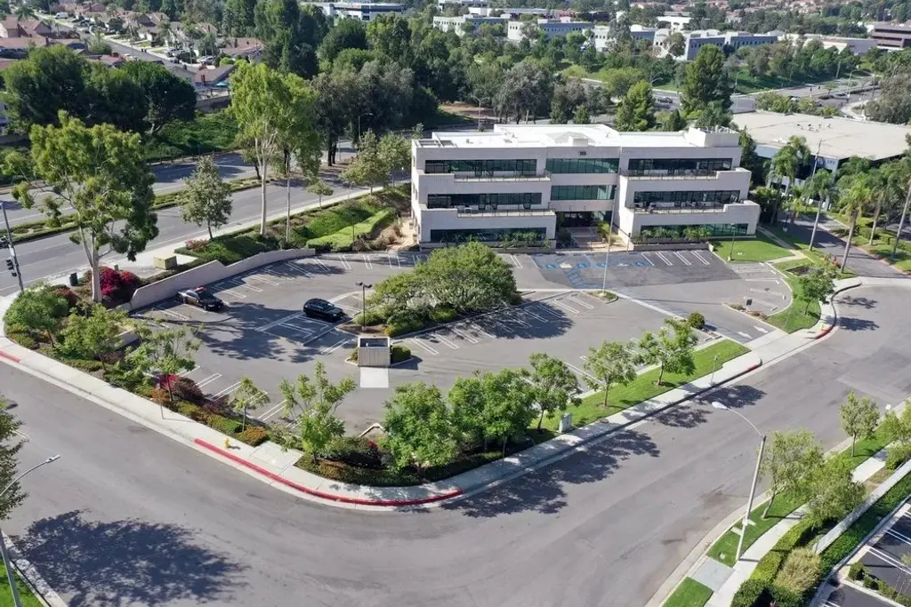 Aerial view of a multi story office building with landscaped parking islands and perimeter planting