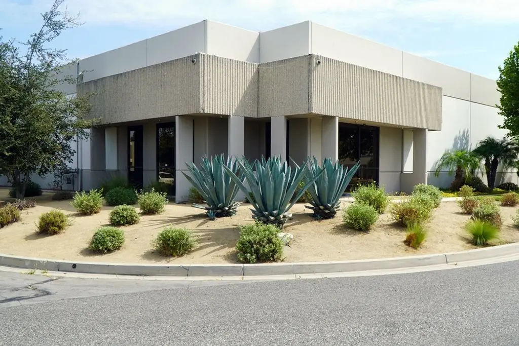 Agave and low water shrub planting in gravel beds in front of a concrete office building