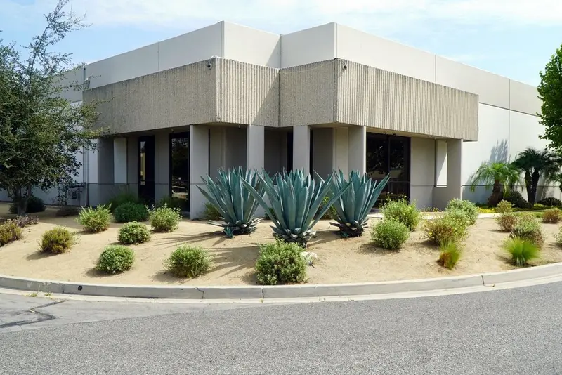 Agave and low water shrub planting in gravel beds in front of a concrete office building